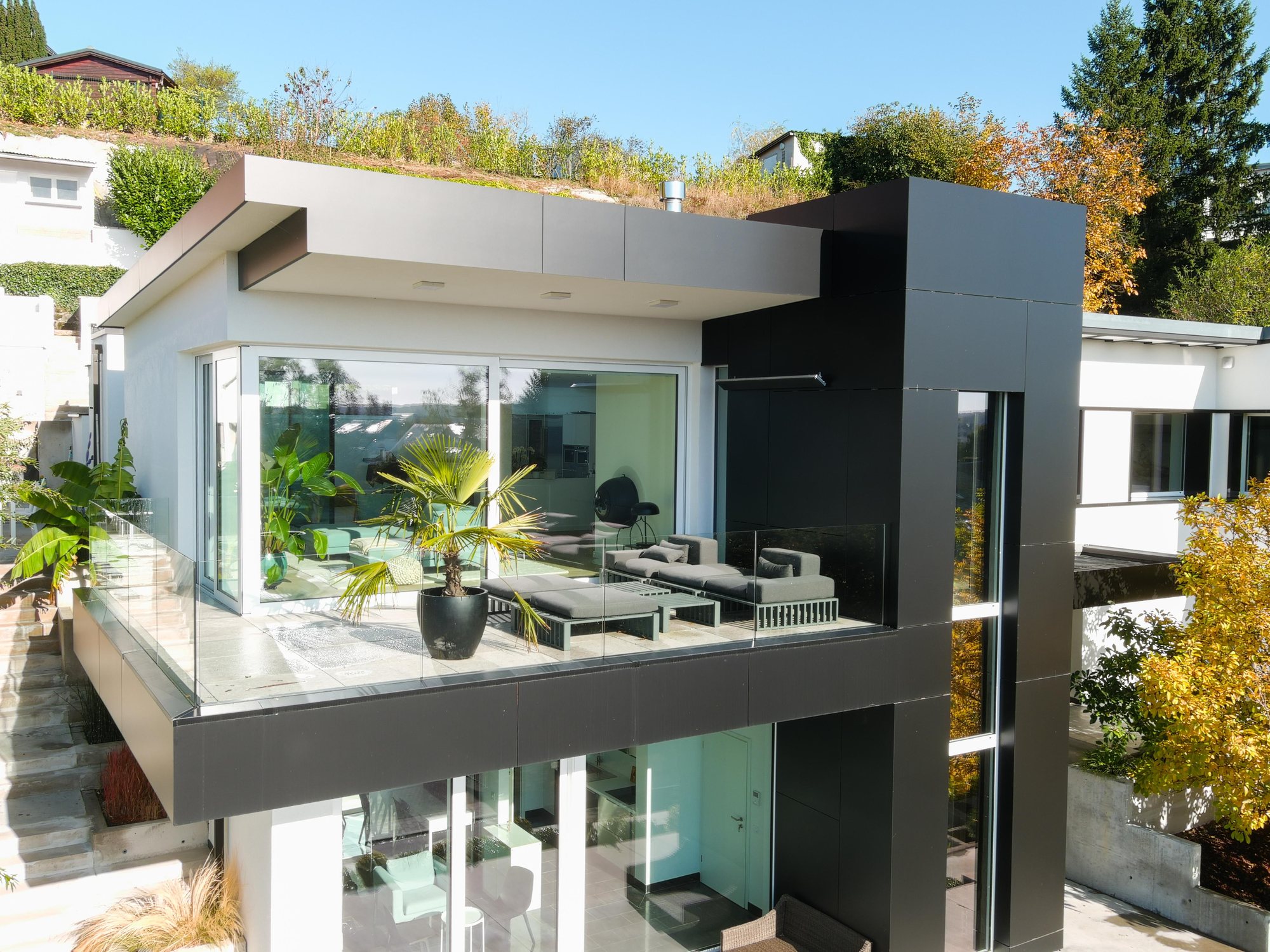 Einzelhaus am Hang mit umlaufender Terrasse und Blick ins Tal